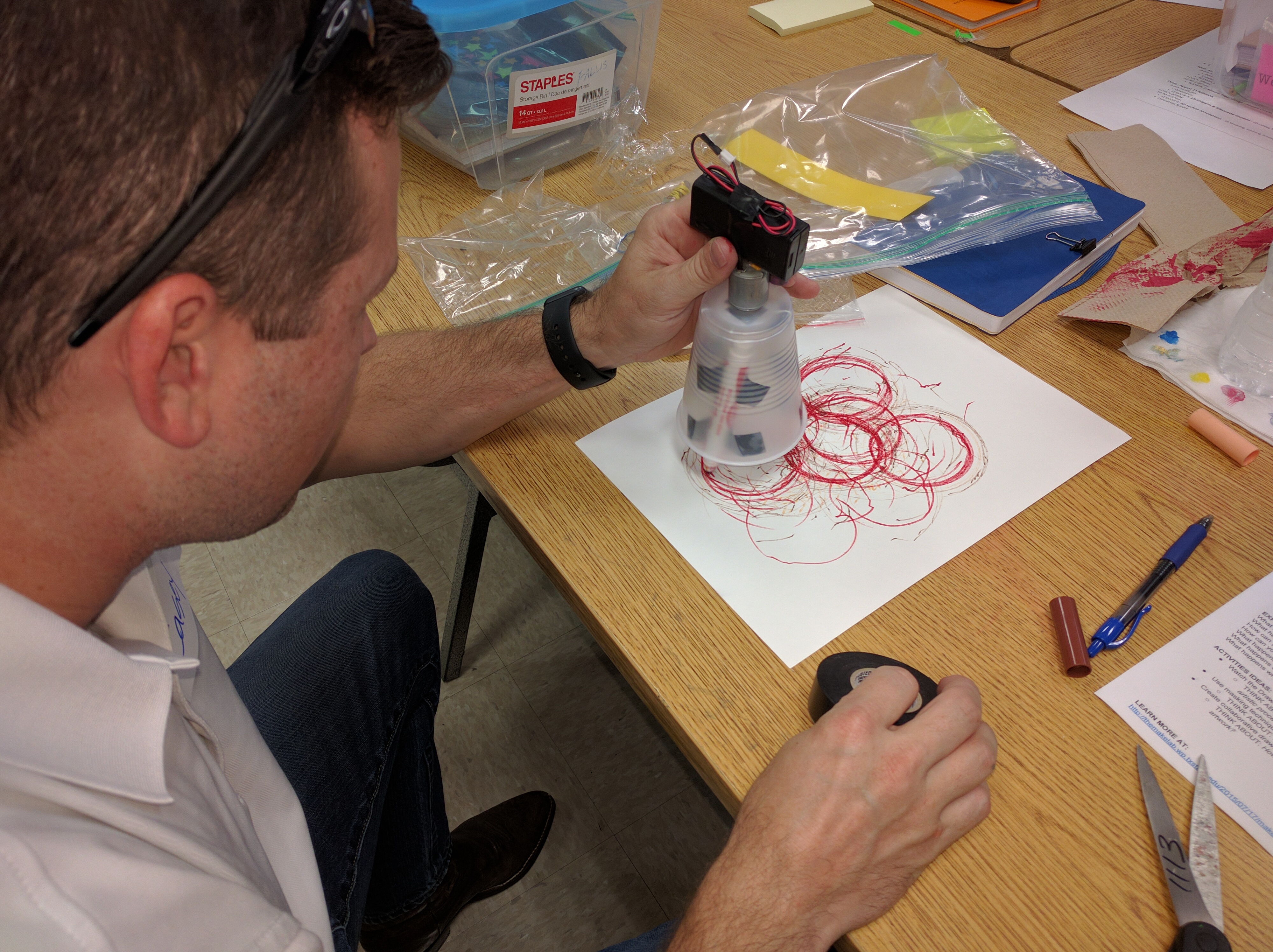 Student artifact example: Drawing machine with markers, disposable cup, tape, DC motor, AA battery pack